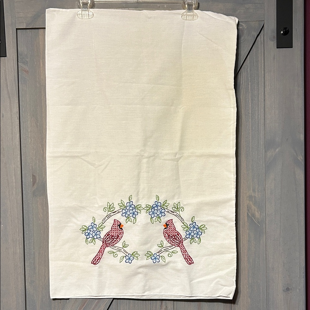 A vintage crème hand-embroidered pillowcase featuring a cardinal bird design